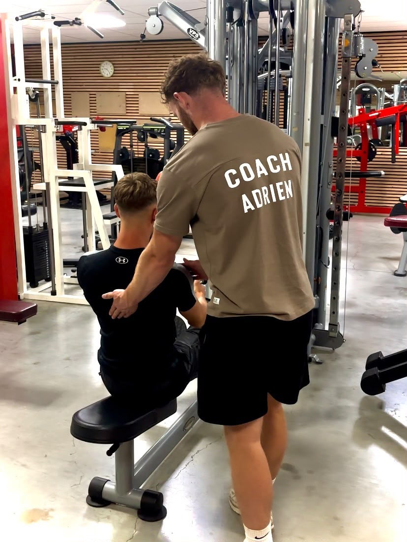 Coach Adrien accompagnant un client en salle